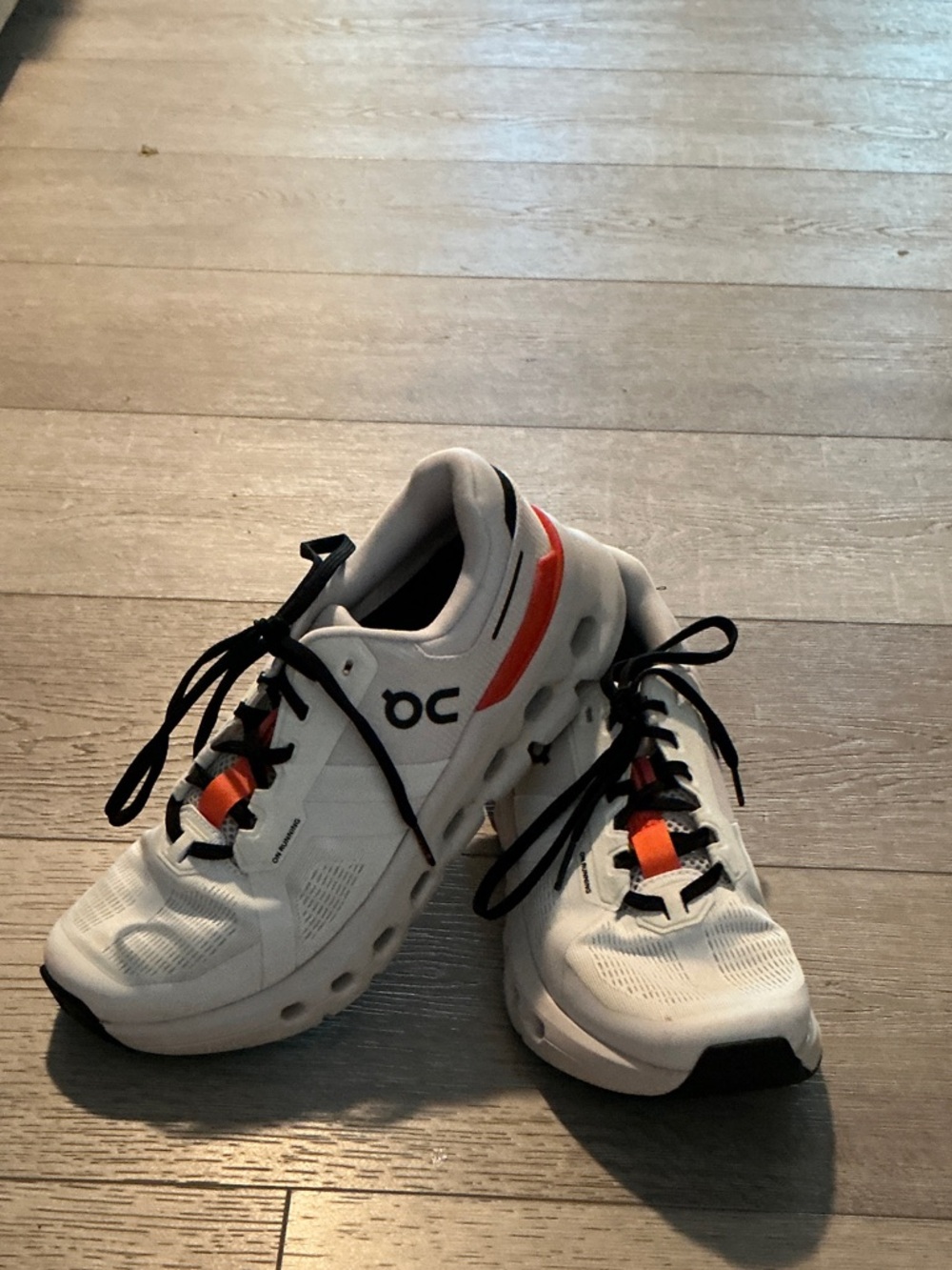 On Running White Sneakers with Orange Accents and Black Laces